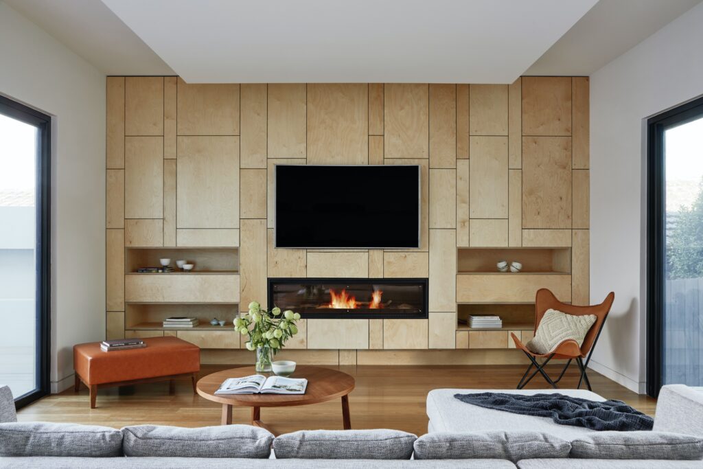 Contemporary living room in a Calgary home, featuring a sleek fireplace and mounted TV, embodying modern comfort and style.