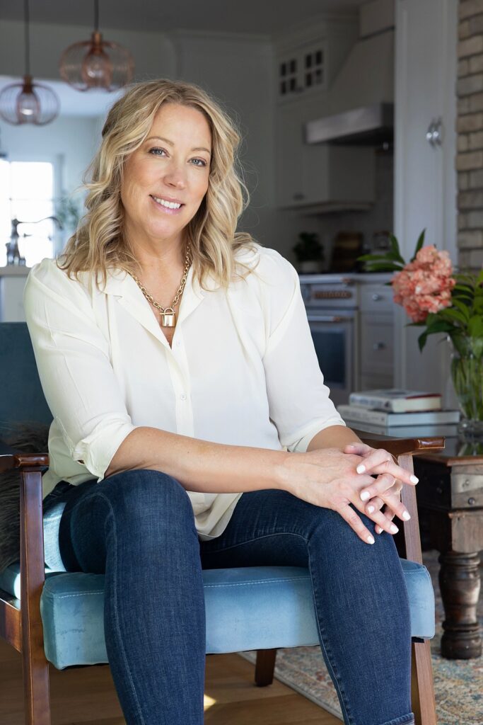 Lesley Hauville, experienced Calgary real estate agent, relaxing in the elegant living room of a property available for sale in Calgary, Alberta.